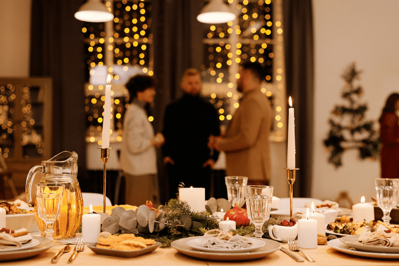 Christmas Dinner Table with Friends Standing Behind